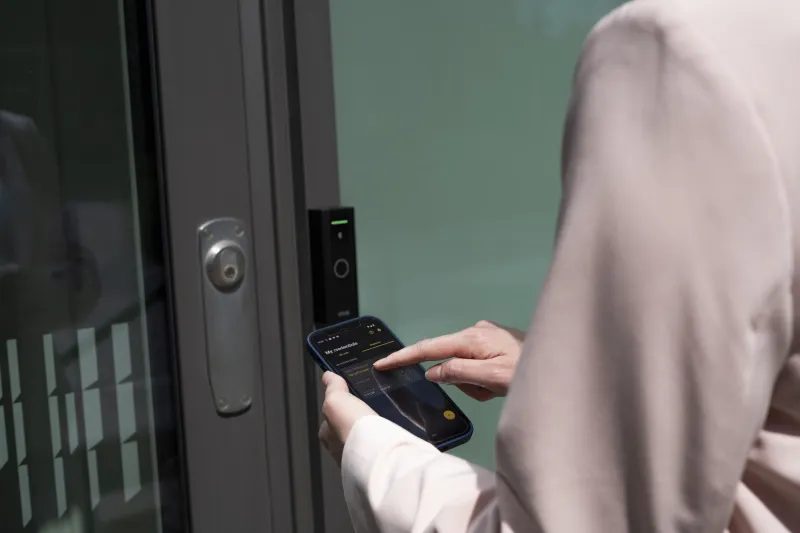 Pengguna membuka pintu dengan aplikasi ponsel pada reader Axis