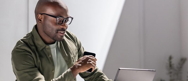 Karyawan bekerja dengan Microsoft 365 di laptop dan ponsel